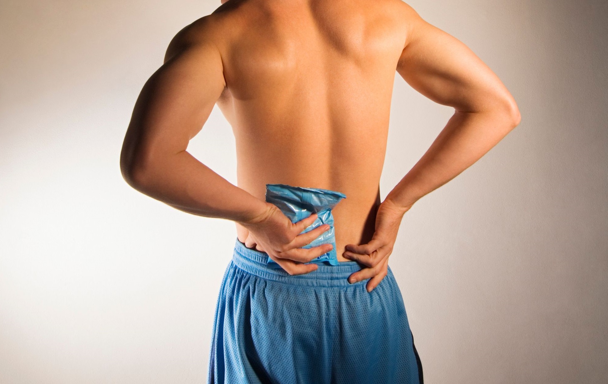Man Using Ice Pack For Back Pain Relief